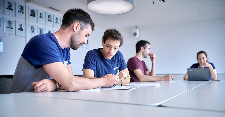 Students bend over study materials (photo: University of Bern)